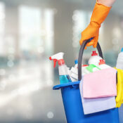 A domestic helper carrying bucket full of cleaning equipment and solutions.