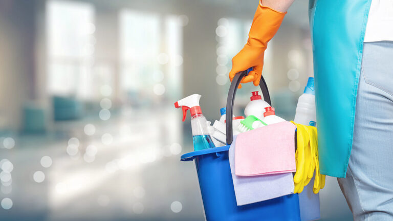 A domestic helper carrying bucket full of cleaning equipment and solutions.