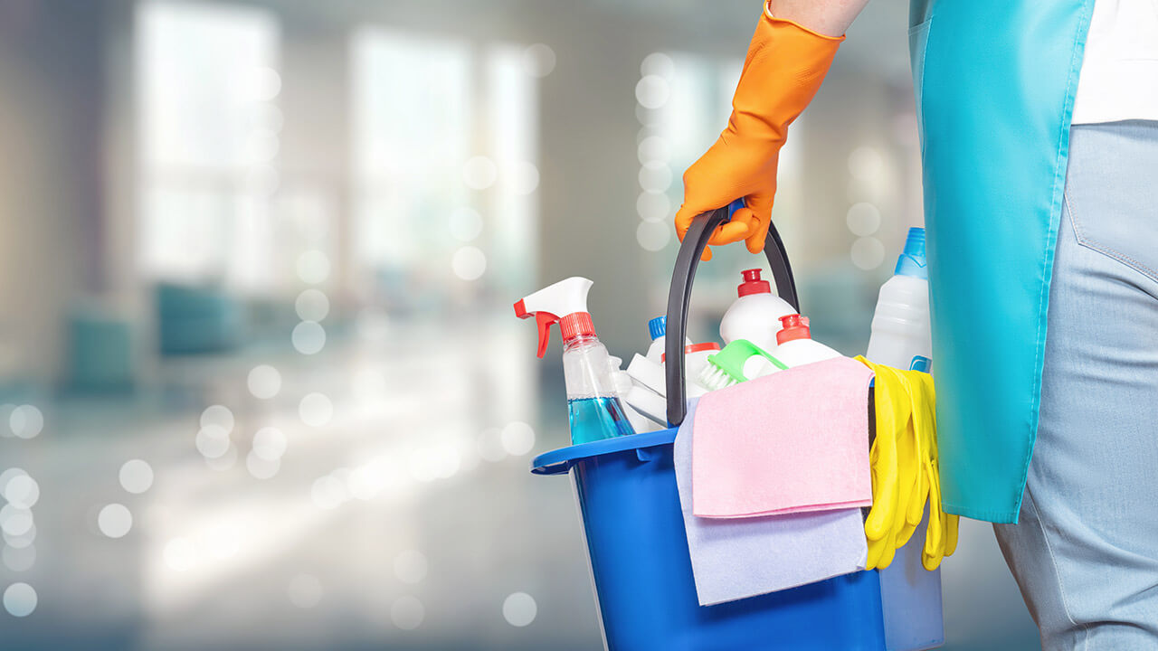 A domestic helper carrying bucket full of cleaning equipment and solutions.