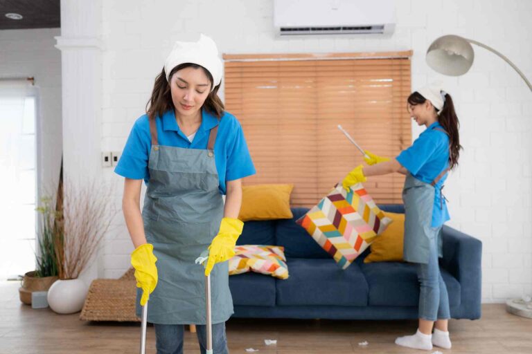 Two house help cleaning the room.