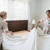 Two maids making a bed together, illustrating the difference between hiring a transfer maid or a new helper for household needs in Singapore.