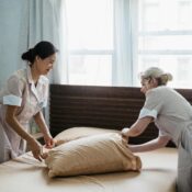 Two professional maids making a bed together in a bright, tidy room—highlighting the importance of choosing the best maid agency in Singapore.